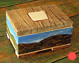 Caja con cerámica, montañas y cielo